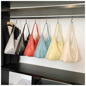 Selection of minimalist glossy leather tote bags in various colors on display racks