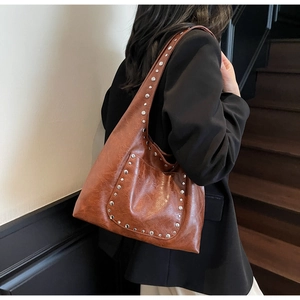 Détail du sac hobo marron vintage en simili cuir avec des rivets argentés élégants
