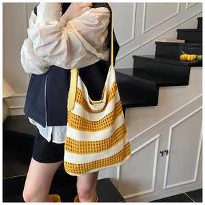 Detail of yellow and white striped knit hobo bag with textured crochet and leather strap