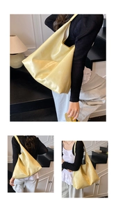 Detail view of large pale yellow hobo bag with pearlescent glossy finish and wide strap