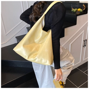 Close-up of a large pale yellow tote bag with silk-like finish shown in a lifestyle setting