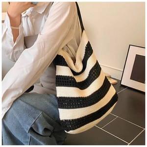 Detail of crochet tote bag with black and white stripes and woven texture on model