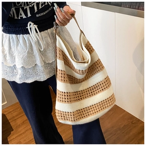 Close-up of hollow striped knit tote bag with premium brown leather shoulder strap
