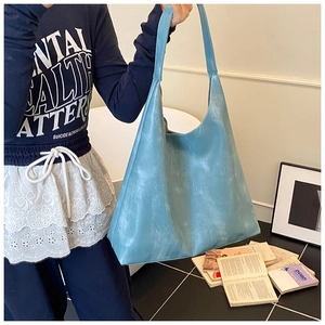 Close-up of sky blue hobo bag showing frosted matte texture and wide shoulder strap
