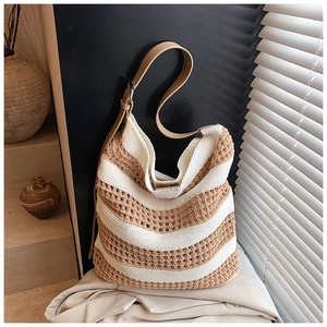 Detailed close-up of striped knit tote bag showing the mesh texture and leather strap