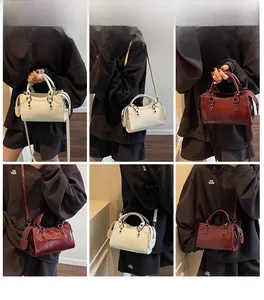 Detailansicht der Retro-Boston-Tasche aus weißem und weinrotem Leder am Model
