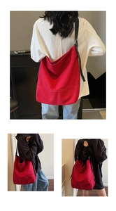 Close-up of large red canvas tote bag with adjustable black leather shoulder straps