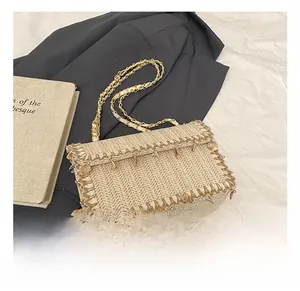 Detailed close-up of straw woven flap bag with gold chain strap and seashell charms