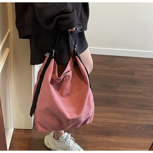 Detail view of pink canvas tote bag showing the textured pleats and black leather strap