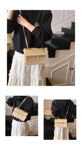Detail of straw woven crossbody bag featuring white tassels and seashell metal charms
