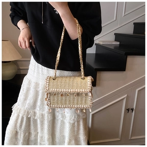 Detail of straw woven bag with delicate lace edges and elegant shell pearl charms