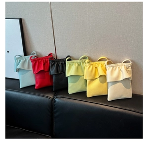 Plusieurs couleurs de sacs de téléphone en cuir à volants sur un banc en cuir noir