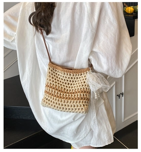 Détail du sac bandoulière en paille tissé main avec nœud en dentelle et pendentif