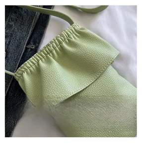 Détail du sac de téléphone en cuir litchi vert clair avec bords plissés nuage