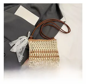 Détail d'un sac bandoulière tissé avec motif évidé et décoration de gland en perles