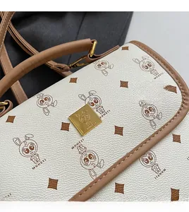 Gros plan sur le cuir grainé et le fermoir doré avec motifs de lapin