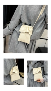 Détail du mini sac de téléphone crème avec rabat à volants et texture cuir grainé