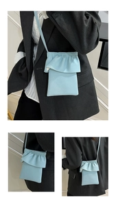 Vues détaillées d'un mini sac de téléphone bleu clair texturé sur un blazer noir chic