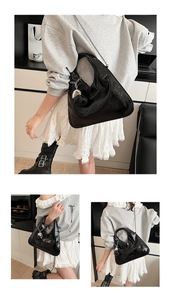 Detail of glossy black pleated leather bag with metal chain and heart charm
