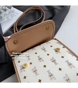 Gros plan sur le fermoir magnétique doré d'un sac à main en cuir blanc vintage
