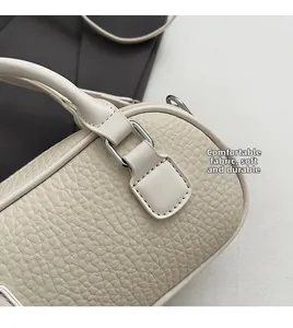Dettaglio della borsa in pelle martellata bianca con cuciture fini e anello a D argento