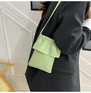 Gros plan du mini sac bandoulière vert crème en cuir avec bordure à volants