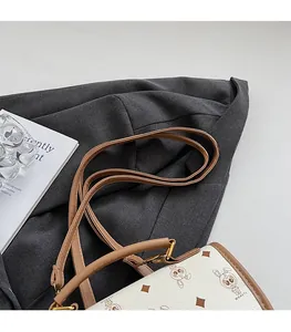 Détail du sac crème avec motif lapin et fine bandoulière réglable en cuir marron