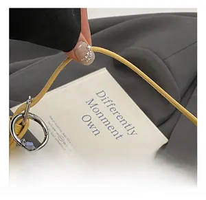 Detail of yellow lychee leather handbag with silver metal rings and textured finish