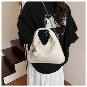 Detail of off-white PU leather bag with pleated texture and heart metal charm