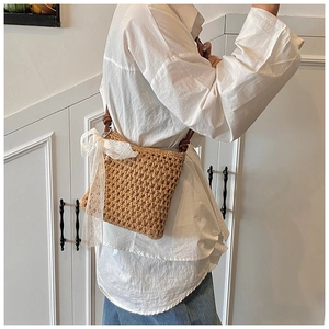 Détail du sac bandoulière en paille tressée avec nœud en dentelle blanche et bandoulière