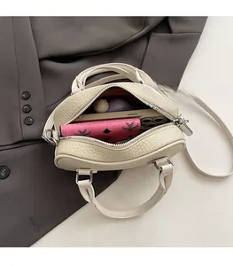 Vista interna della borsa bowling off-white che mostra lo spazio per telefono e portafoglio