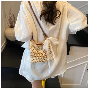 Détail d'un sac à bandoulière tressé avec un grand nœud en dentelle et cuir fin