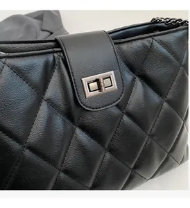 Gros plan détaillé de la texture en cuir noir matelassé et du fermoir en métal foncé