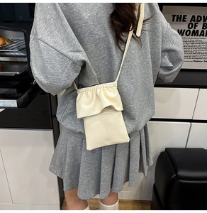Détail du mini sac de téléphone en similicuir grainé blanc cassé avec cordon de serrage