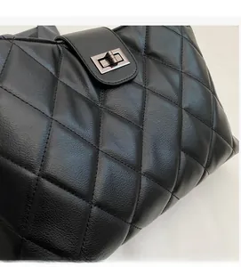 Gros plan du sac cabas matelassé noir avec fermoir tournant en métal industriel