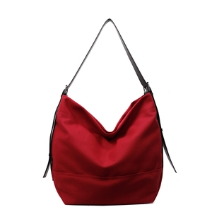 Minimalist red large capacity canvas tote bag with black shoulder strap on white background