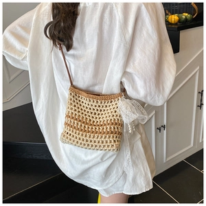 Détail du sac bandoulière tissé ajouré avec nœud en dentelle et pendentif perle d'été