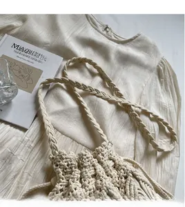 Gros plan du sac seau beige crocheté à la main avec de longues bandoulières tressées