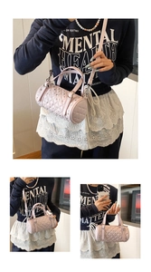 Détail du sac cylindrique matelassé rose avec rivets et bandoulière réglable