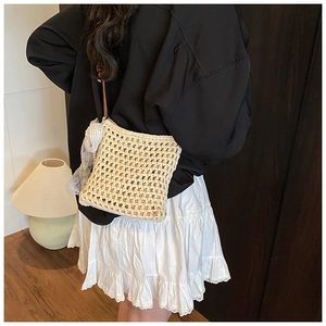 Détail du sac bandoulière tissé ajouré avec nœud en dentelle blanche et cuir brun