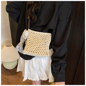 Détail du sac bandoulière tissé ajouré avec foulard en dentelle et pendentif en perles