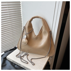 Close-up of khaki triangle hobo bag with PU leather texture and silver chain strap