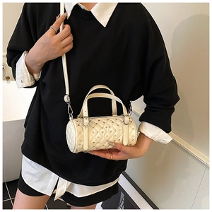 Détail du sac cylindre blanc crème avec strass et cuir PU au motif matelassé