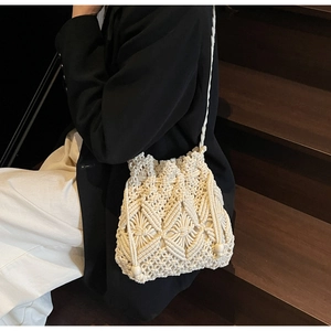 Detail of bohemian beige woven bucket bag showing intricate diamond pattern texture