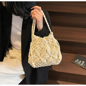 Vue détaillée de la texture au crochet et de la fermeture à cordon du sac seau tissé