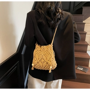 Détail d'un sac seau en macramé fait main avec des franges et des perles blanches