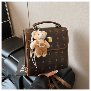 Détail d'un sac à main vintage avec fermoir doré et accessoire d'ours en peluche