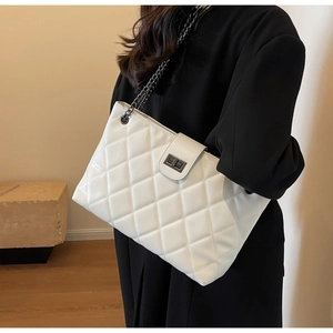 Détail du sac cabas en cuir matelassé blanc avec chaîne en métal et fermoir rotatif