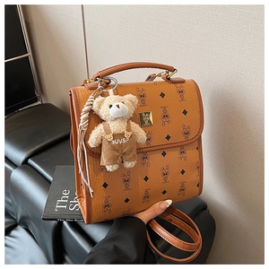 Gros plan d'un sac à dos vintage marron avec motifs classiques et breloque ourson