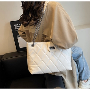 Détail de ce sac fourre-tout blanc en similicuir matelassé avec bandoulière chaîne